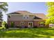 The home's backyard features a manicured lawn, brick accents, and lush, mature trees at 734 Richland Way, Westfield, IN 46074