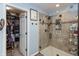Walk-in shower boasts decorative tile, a glass door, and built-in shelving for an enhanced spa-like experience at 8084 Lawrence Woods Pl, Indianapolis, IN 46236