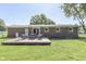 A brick house with a wooden deck and cozy seating arrangement in the backyard and a manicured lawn at 8246 S Franklin Rd, Indianapolis, IN 46259