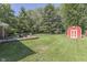 Landscaped backyard with a lush lawn, a shed, a playset, and a inviting deck area at 8246 S Franklin Rd, Indianapolis, IN 46259