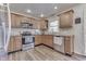 Kitchen with wooden cabinets, stainless appliances, and decorative tile backsplash at 8246 S Franklin Rd, Indianapolis, IN 46259