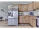 Kitchen with stainless steel refrigerator, wooden cabinets, and a view to the living area at 8246 S Franklin Rd, Indianapolis, IN 46259
