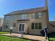 A two-story home back view with a brick patio and expansive windows at 8400 Harrison Pkwy, Fishers, IN 46038