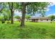 A large grassy backyard features mature trees and a view of the back of the house at 9002 Walton St, Indianapolis, IN 46231