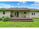 View of the back of the house with a wood deck and a grassy backyard at 9002 Walton St, Indianapolis, IN 46231