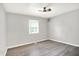 This bright bedroom features a ceiling fan, window and light gray walls and wood floors at 9002 Walton St, Indianapolis, IN 46231