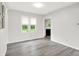 Cozy living room featuring gray laminate flooring, white walls, and natural light from two large windows at 9002 Walton St, Indianapolis, IN 46231