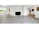 Bright living room featuring gray laminate flooring, white walls, and two entry doorways at 9002 Walton St, Indianapolis, IN 46231