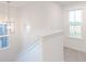 Bright hallway with modern chandelier, white trim, and natural light streaming through windows at 9136 Anthem Ave, Plainfield, IN 46168