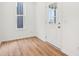 Brightly lit room featuring light wood floors, a window, and a white door at 9160 Anthem Ave, Plainfield, IN 46168