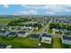 The aerial view shows a residential area with orderly streets and sidewalks, a pond and a distant water tower at 9829 Hulton Rd, Pendleton, IN 46064