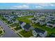 An aerial view of a neighborhood showcases many houses, green spaces, and well-maintained streets, all under a cloudy sky at 9829 Hulton Rd, Pendleton, IN 46064
