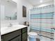Well-lit bathroom featuring a vanity with a mirror, and a shower with a decorative striped shower curtain at 9829 Hulton Rd, Pendleton, IN 46064
