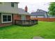 Beautiful backyard showcases an expansive lawn, a deck, brick accents, and new privacy fence at 1004 Nevelle Ln, Carmel, IN 46032