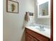 Bathroom vanity featuring wood cabinetry, white countertops, and decorative fern art at 1004 Nevelle Ln, Carmel, IN 46032