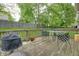 Outdoor deck with dining set offers serene view of lush backyard, ideal for relaxation and gatherings at 1004 Nevelle Ln, Carmel, IN 46032