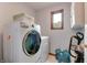 Functional laundry room equipped with a modern washer and dryer, shelving, and a window at 1004 Nevelle Ln, Carmel, IN 46032
