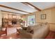Cozy living room with a fireplace, wood beams, and sliding doors leading to the backyard at 1004 Nevelle Ln, Carmel, IN 46032