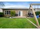 Backyard with lush green lawn, swing set, patio furniture, and privacy landscaping at 11040 Brave Ct, Indianapolis, IN 46236