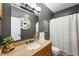 Bathroom with granite countertop, bronze fixtures, decorative mirror, and shower with white curtain at 11040 Brave Ct, Indianapolis, IN 46236