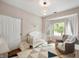 Cozy bedroom featuring a crib, accent rug, glider chair, and bright natural lighting at 11040 Brave Ct, Indianapolis, IN 46236