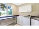 Bright laundry room with washer, dryer, storage cabinets, and a large window offering natural light at 11575 Freeport Dr, Carmel, IN 46032