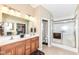 Bright bathroom features a double vanity, large mirror, and glass-enclosed shower, with access to a closet at 11692 Seven Oaks Dr, Fishers, IN 46038