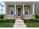 Charming front porch with brick columns, decorative wreath, and potted flowers, enhanced by green bushes at 13048 Minden Dr, Fishers, IN 46037