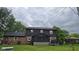 The back of the house features a screened-in porch and an expansive yard with lush greenery at 131 Creek View Ct, Greenfield, IN 46140