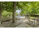 Inviting backyard with an in-ground pool, a wooden deck with seating, and mature trees at 1311 N Eaton Ave, Indianapolis, IN 46219