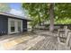 Comfortable backyard deck area featuring wooden benches, chairs, table, and mature trees at 1311 N Eaton Ave, Indianapolis, IN 46219