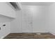 A finished basement shows a door and storage shelves, with wood-look flooring and white walls at 1311 N Eaton Ave, Indianapolis, IN 46219