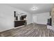 Open-concept living room view featuring new flooring, kitchen access, and a stone fireplace at 1311 N Eaton Ave, Indianapolis, IN 46219