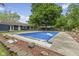 Home's in-ground pool with a view of the backyard, surrounding trees, and the home's exterior at 1311 N Eaton Ave, Indianapolis, IN 46219