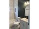 Renovated bathroom with white subway tile, dark green wall, and modern white vanity at 1318 Hoyt Ave, Indianapolis, IN 46203