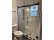 Updated bathroom featuring a glass-enclosed shower with black hardware and white tiling at 1318 Hoyt Ave, Indianapolis, IN 46203