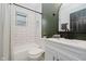 Bathroom featuring white tiled shower over tub, modern fixtures, and an elegant color pallete at 1318 Hoyt Ave, Indianapolis, IN 46203