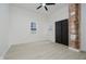 Spacious bedroom with exposed brick accent wall, hardwood floors, and modern ceiling fan at 1318 Hoyt Ave, Indianapolis, IN 46203