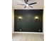 Modern bedroom with black accent wall, light wood flooring, wall mounted lighting, and a ceiling fan at 1318 Hoyt Ave, Indianapolis, IN 46203