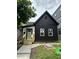 Newly renovated two-story home showcasing a black and white color scheme with new windows and wood porch at 1318 Hoyt Ave, Indianapolis, IN 46203