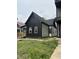 Side view of renovated house featuring black and white siding, new windows and foundation at 1318 Hoyt Ave, Indianapolis, IN 46203