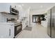 Modern kitchen with stainless steel appliances, white cabinets, and open layout to the dining area at 1318 Hoyt Ave, Indianapolis, IN 46203
