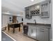 Wet bar in the basement with granite countertops and stainless steel beverage refrigerator at 13485 Mancroft Dr, Fishers, IN 46037
