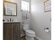Well-lit half bathroom with modern fixtures, a wood vanity, and stylish decor at 13485 Mancroft Dr, Fishers, IN 46037