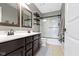 Bathroom with double sink vanity, decorative mirror, and a shower-tub combo at 13485 Mancroft Dr, Fishers, IN 46037
