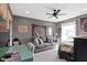 Spacious bedroom with a gray sofa, a cozy bed, a ceiling fan, and a bright window view at 13485 Mancroft Dr, Fishers, IN 46037