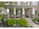 Inviting front porch with stone columns and seating, complemented by manicured landscaping and stone pathway at 13485 Mancroft Dr, Fishers, IN 46037