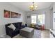 Cozy living room with a large blue sofa, ottoman, bright windows, and a charming chandelier at 13485 Mancroft Dr, Fishers, IN 46037