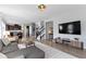 Spacious living area featuring an open layout with a view of the kitchen, stairs, and large television at 13485 Mancroft Dr, Fishers, IN 46037