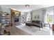 Open-concept living room with a cozy gray sofa, stone fireplace, and natural light streaming through the windows at 13485 Mancroft Dr, Fishers, IN 46037